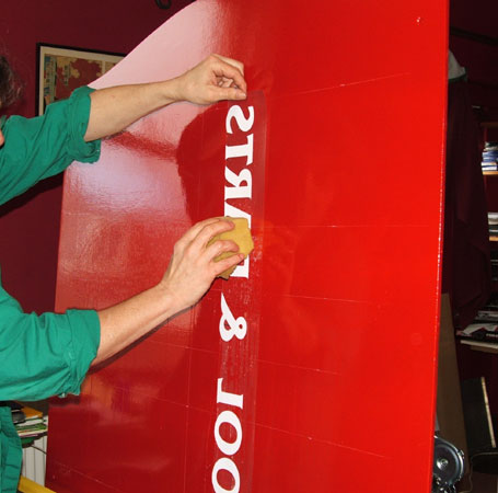 part of the process of applying self adhesive lettering to signs