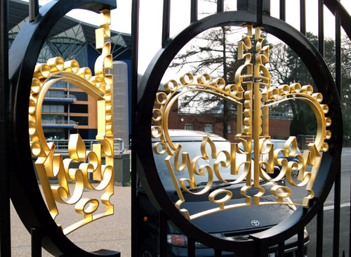 Gold leaf gilding on laser cut mild steel crown  on ornamental metal gates at Ascot racecourse in Berkshire England