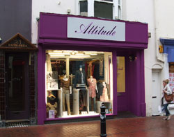 This shop front sign has traditional signwriting on exterior painted wall