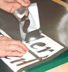 Weeding the background from self adhesive vinyl rolls to reveal the sign lettering