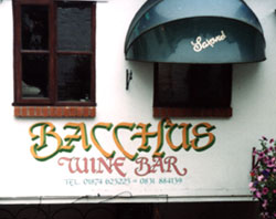 This shop front sign has traditional signwriting on exterior painted wall